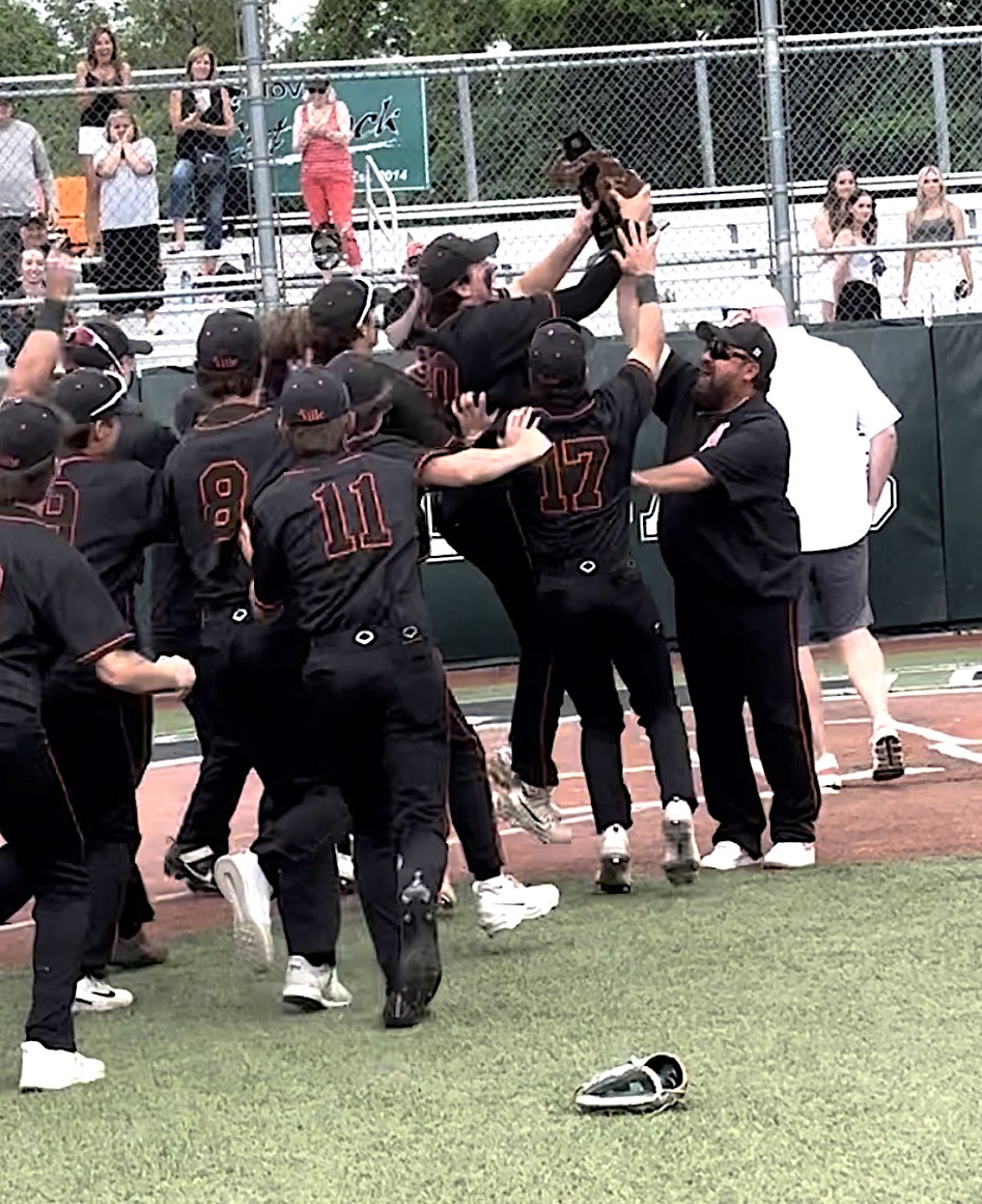 Northville Head Coach Dan Cimini presents the district championship trophy to his team