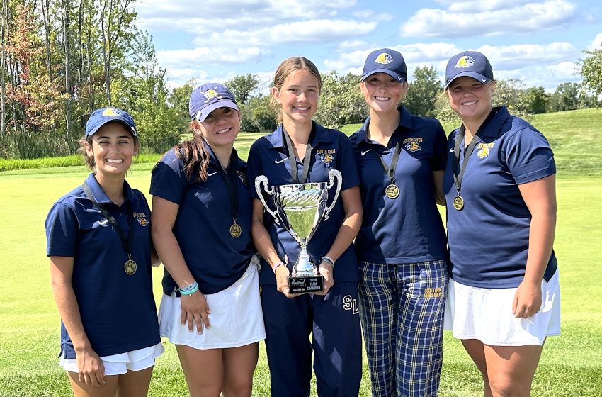 Members of the South Lyon golf team pose with the first-place trophy following their triumphant day at the inaugural Dan Young Invitational.