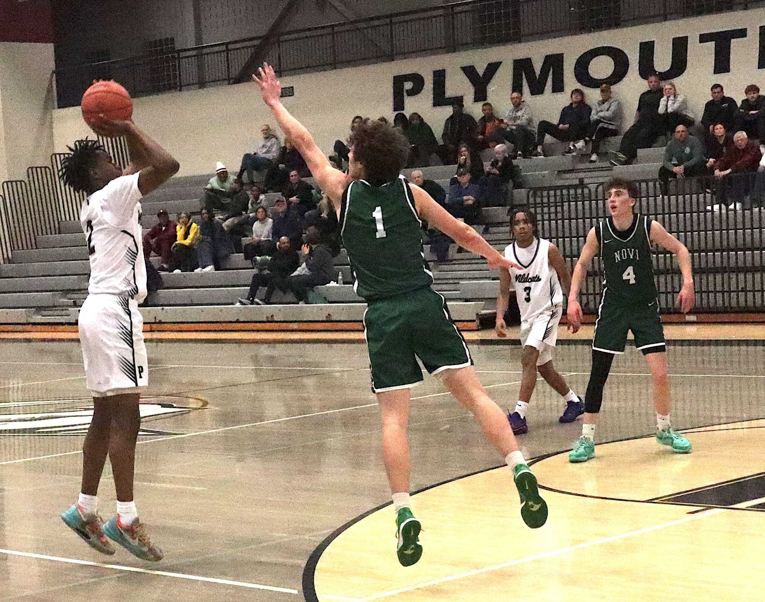 Zerry Rue releases a jump shot over Brendan Lynch