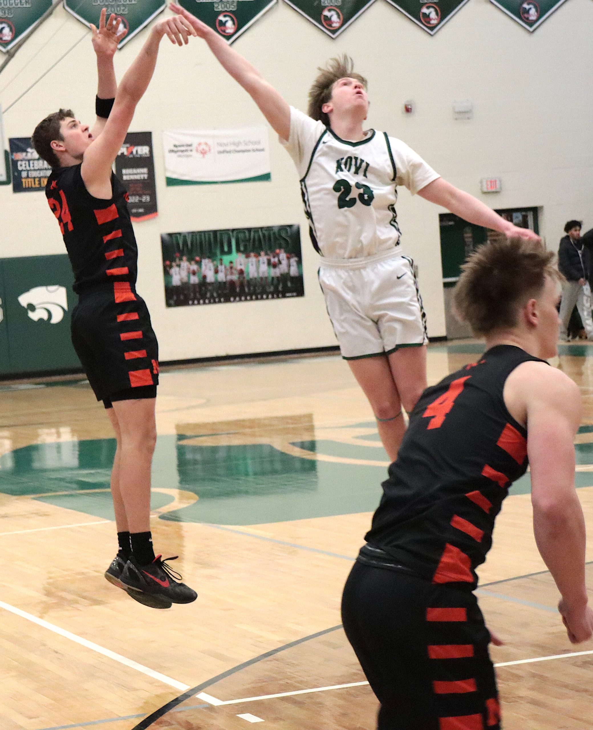 nnthriller9 - Social House News Brody Grezak releases a shot over Novi senior Chase LeFevre