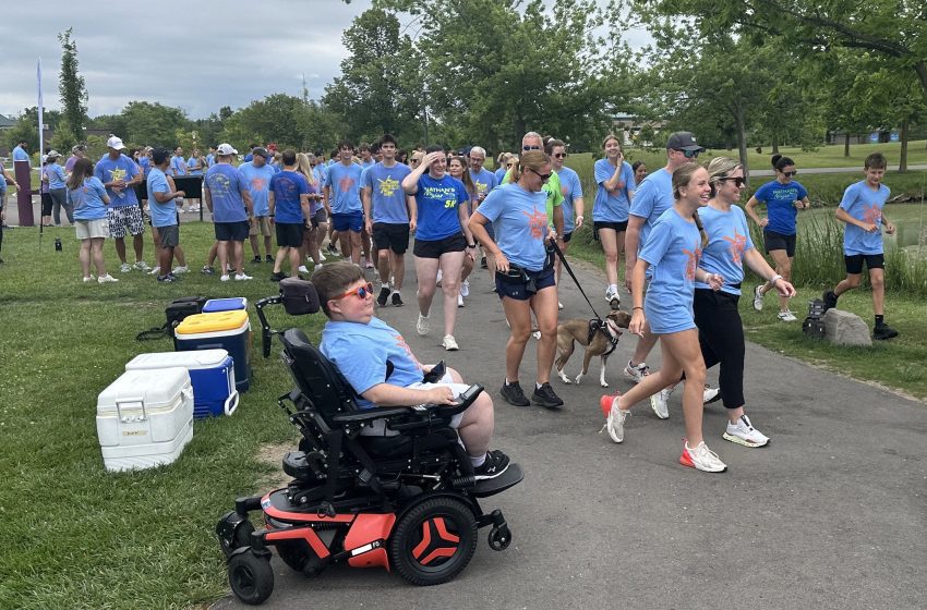Nathan Miller cheers on participants of Sunday's Nathan's Ninja's 5K held at Canton's Heritage Park.