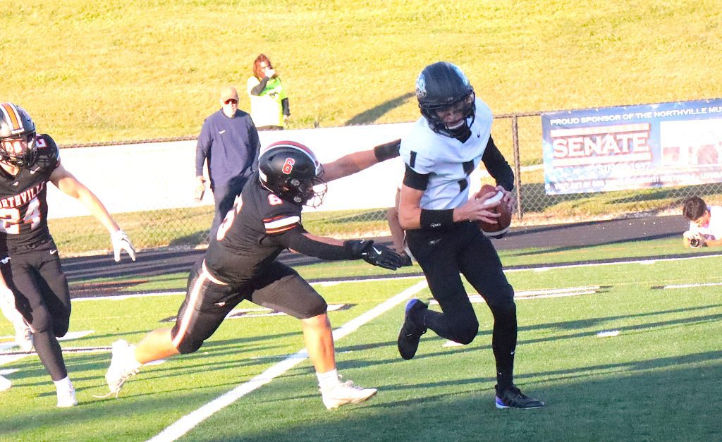 Northville senior linebacker Robbie Kehoe pursues Plymouth quarterback Drew Jansen during the first quarter of Friday's game at Northville.