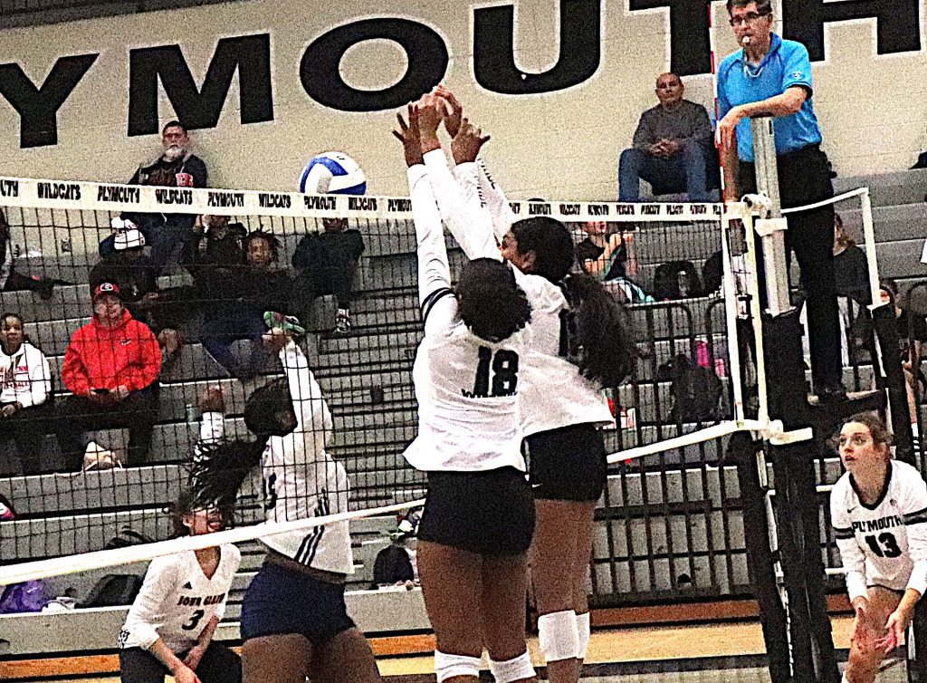 Plymouth middle blockers Jordyn Holly (18) and Tanvi Paturi combine for an imposing double block Tuesday night against John Glenn.