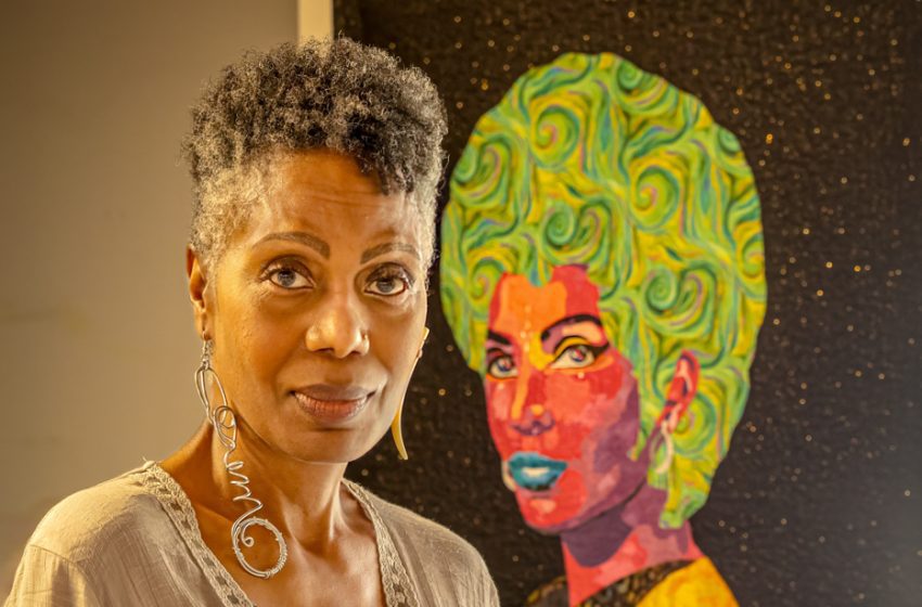 An artist stands beside her painting at the 2024 Emerge! art festival.