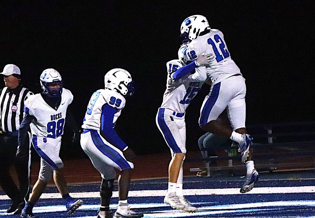Salem players celebrate after Nye Turner's (12) pick six against Livonia Stevenson.