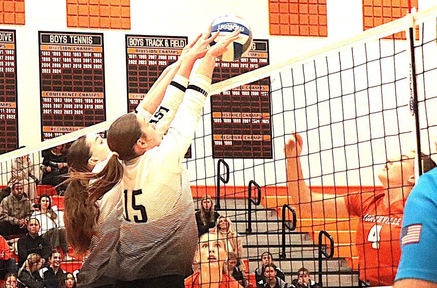 South Lyon East's Brooke Scheuher (15) combines with a teammate for a successful double block against Northville.