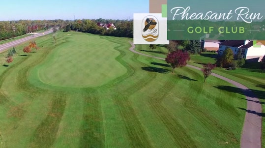 Aerial view of a neatly mowed golf fairway with trees on the sides, at Pheasant Run Golf Club, banner visible in the top-right corner.