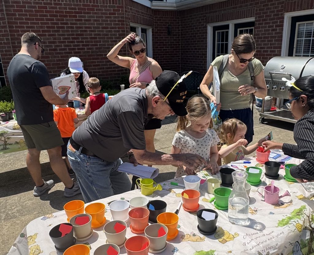 A Waltonwood resident, who is also a Vietnam veteran, helped a camper learn how to plant seeds at one of the seven stations of The Hundred Acre Waltonwood.