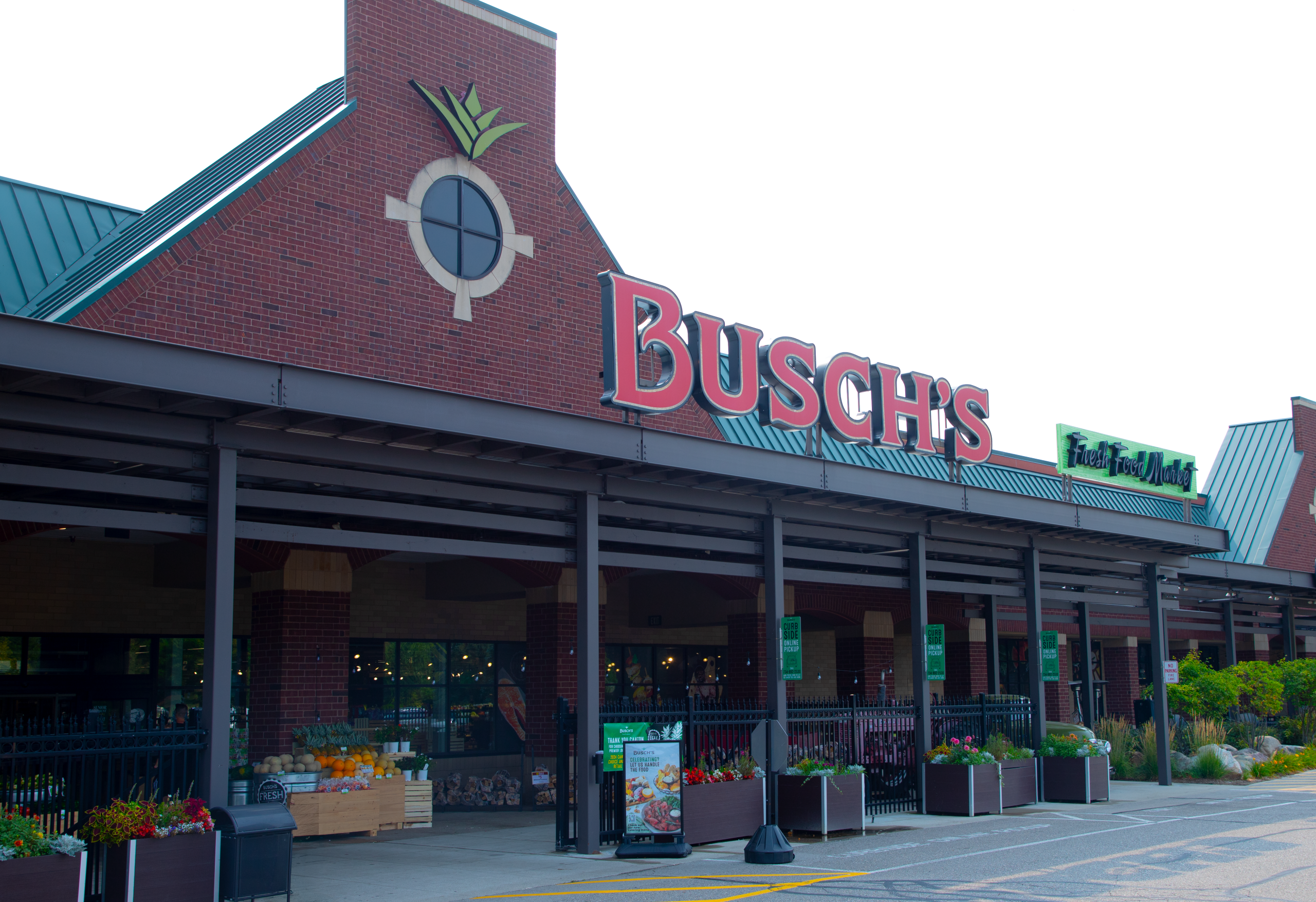 Canton storefront 1 - Social House News Busch's Fresh Food Market storefront with red brick exterior, green metal roof, and produce displays outside the entrance