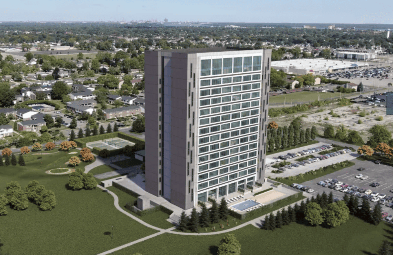 Screen Shot 2026-08-19 at 121053 PM - Social House News A tall modern office tower surrounded by green lawns, trees, walking paths, and a parking lot on a campus-like setting.